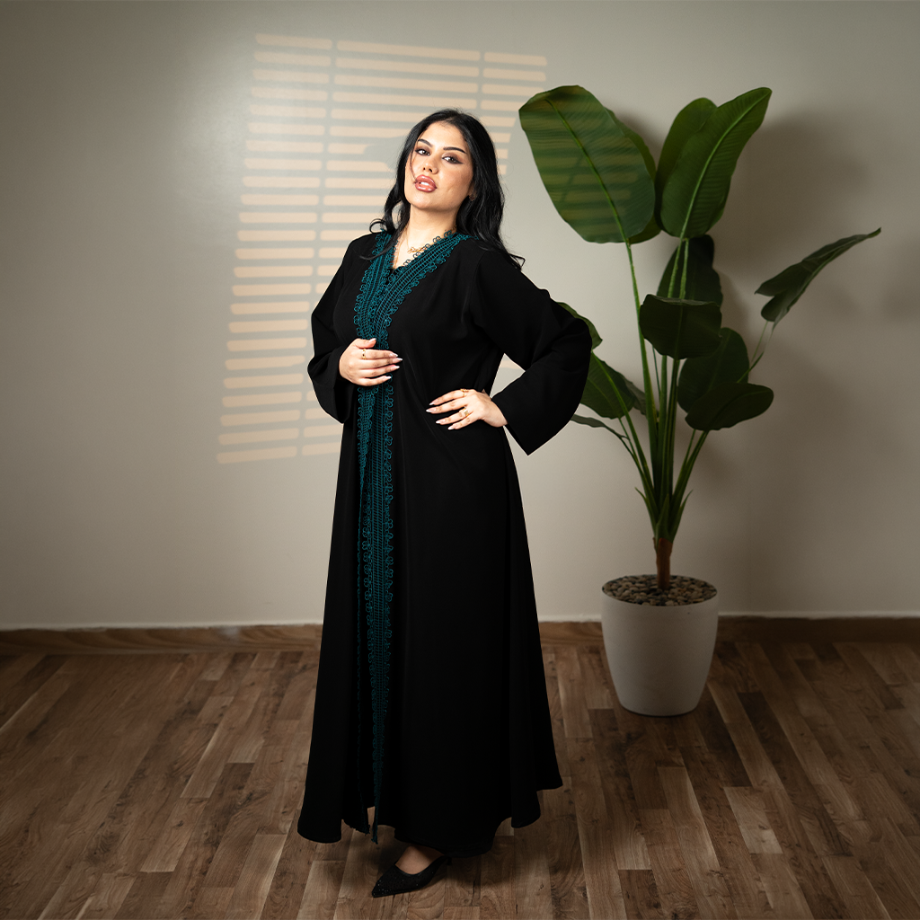 عباية لينا كوين (Linnaa Queen) — عباية سوداء بتطريز بترولي فاخر يمتد على كامل الفتحة الأمامية